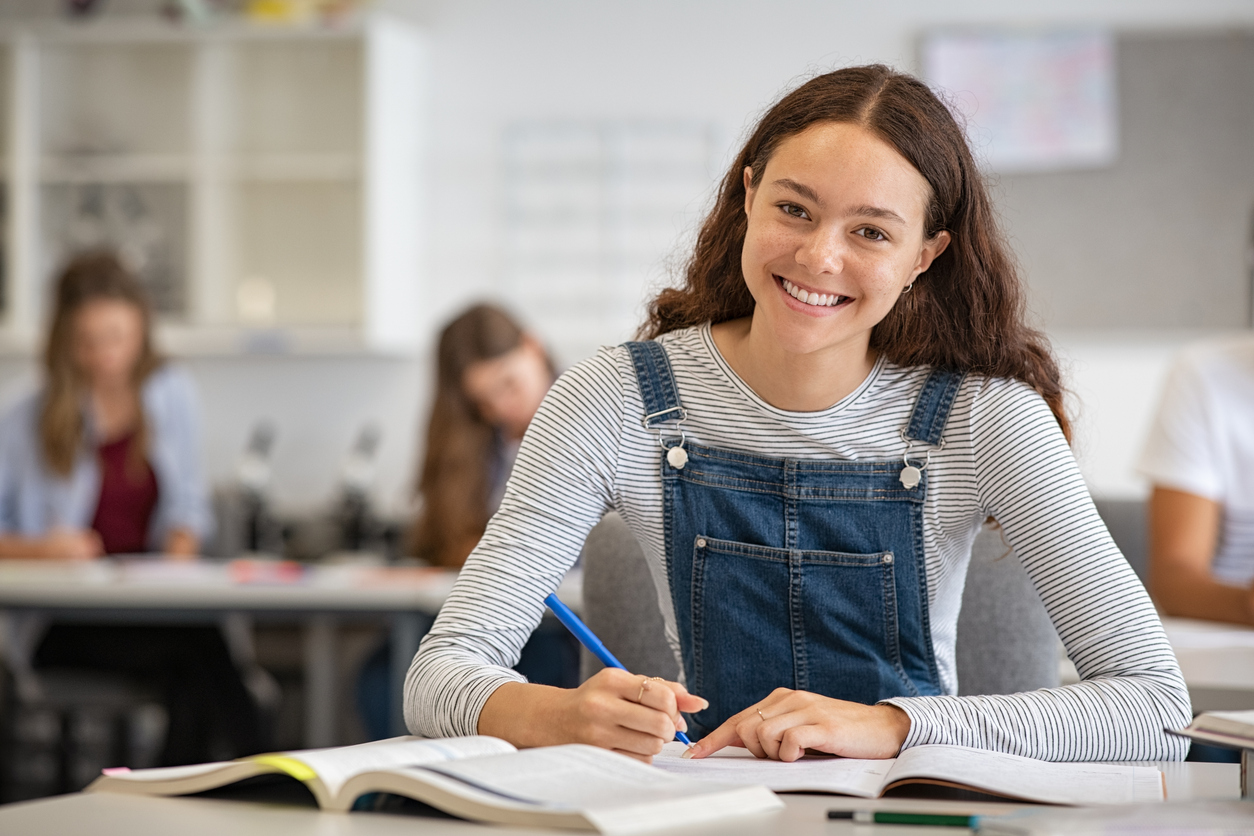 Happy high school student at desk