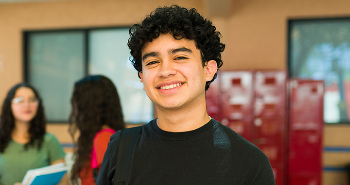 Student smiling outside a school