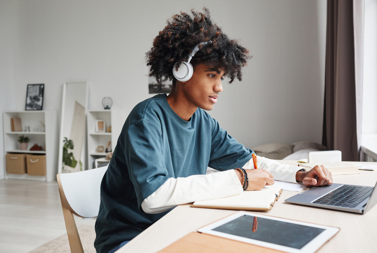 Student with Headphones and Laptop Viewing Online Class